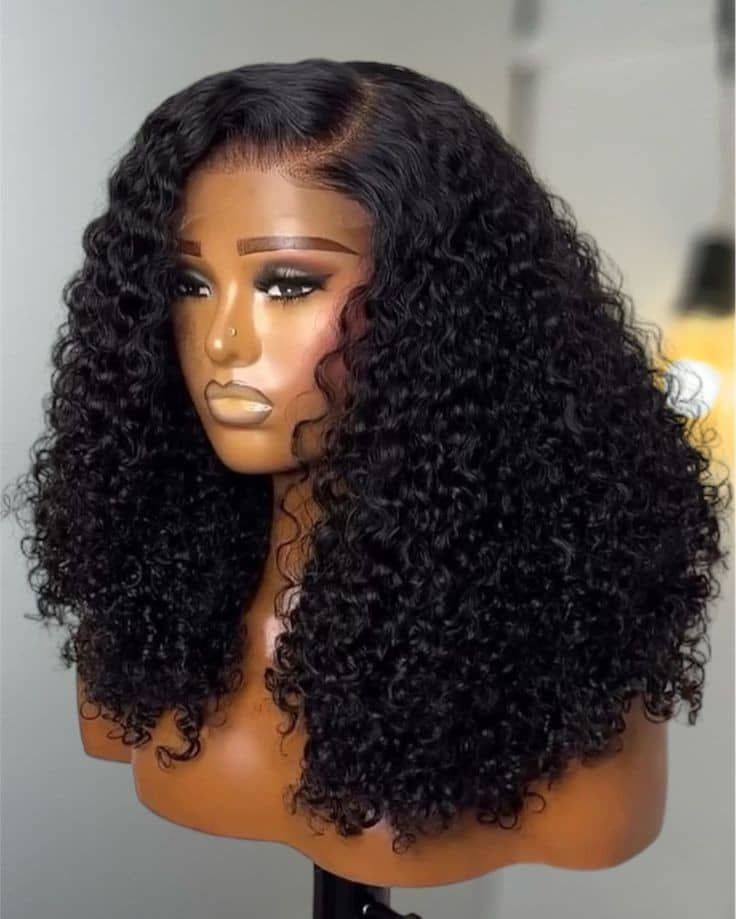 Black shoulder-length curly wig with a side part displayed on a mannequin.