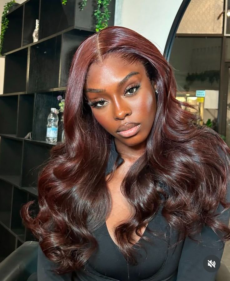 Closer view of a model wearing a reddish-brown wig with loose curls and a centre part.