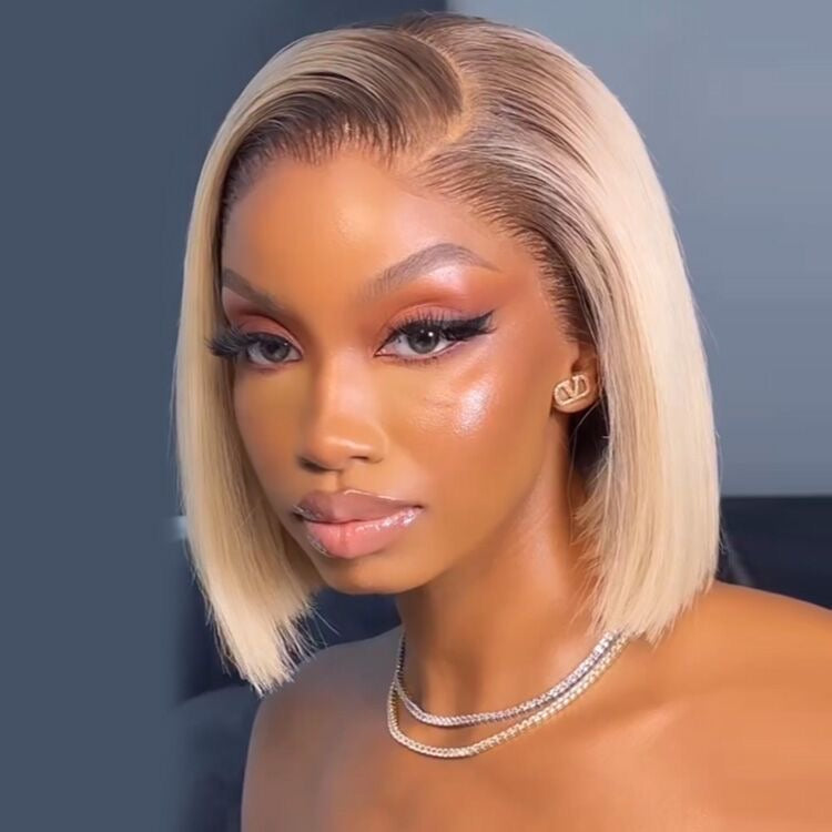 Model wearing a blonde blunt-cut bob with a side part.