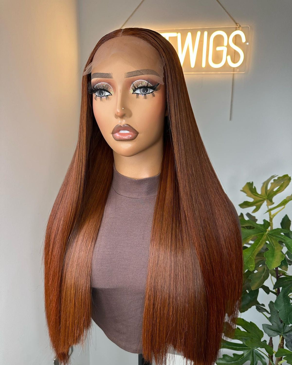 Long copper-brown straight wig with a centre part displayed on a mannequin.